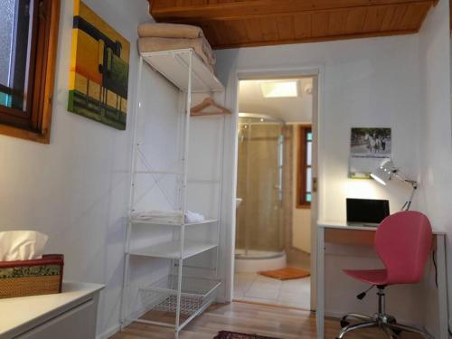 une pièce avec un bureau et une chaise rouge dans une pièce dans l'établissement Quirky Cottage in Centre of Maleny, Walk Everywhere, à Maleny