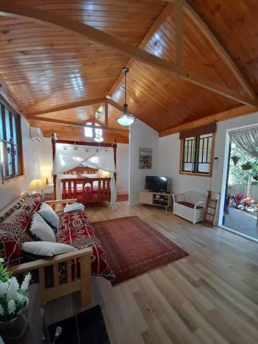 a large living room with a wooden ceiling and a couch at Quirky Cottage in Centre of Maleny, Walk Everywhere in Maleny