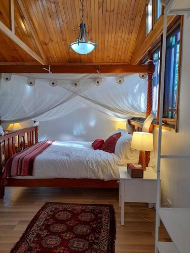 a bedroom with a canopy bed in a room at Quirky Cottage in Centre of Maleny, Walk Everywhere in Maleny