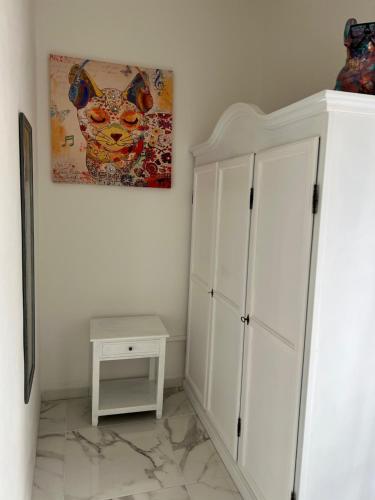 a room with a white cabinet and a painting on the wall at Da Tea in San Teodoro