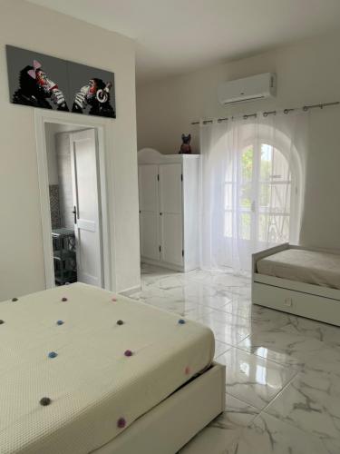 a white bedroom with a bed and a tiled floor at Da Tea in San Teodoro