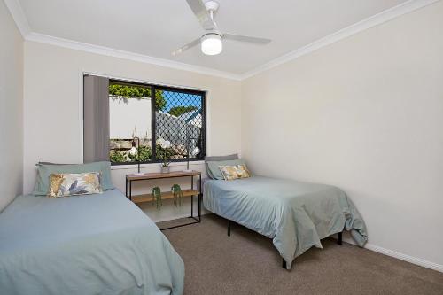 1 dormitorio con 2 camas y ventana en Terbium Sanctuary, en Brisbane