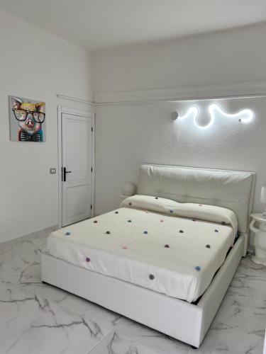 a white bedroom with a white bed with polka dots at Da Tea in San Teodoro