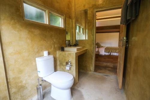 a bathroom with a white toilet and a sink at Down The Rabbit Hole in Ubud