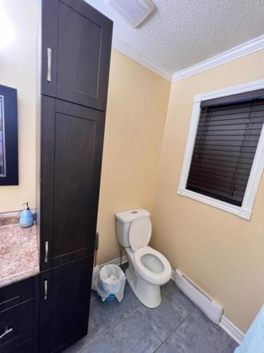a bathroom with a toilet and a window at Faites comme chez vous in Gatineau