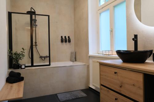 uma casa de banho com um lavatório e uma banheira com um estofamento em CasaLuxe: Familienfreundliche 115m² in der Stadtmitte em Günzburg