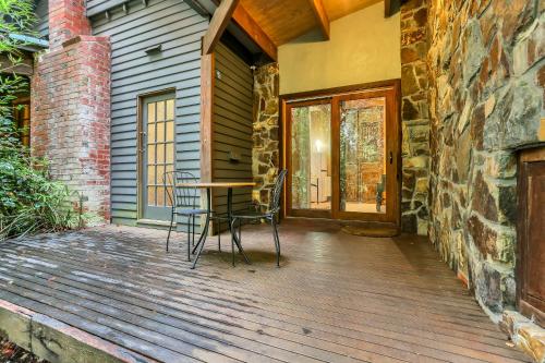 um deque de madeira com uma mesa e cadeiras numa casa em Birch Suite - Rocky Creek Art Garden em Olinda