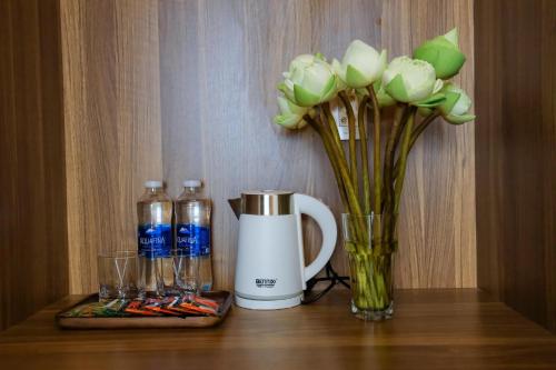 a coffee maker and a vase of flowers on a table at Havana Con Dao Hotel in Con Dao