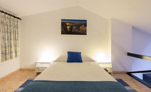 a bedroom with a bed with a blue pillow on it at Apartamentos Azul Mar in Albufeira