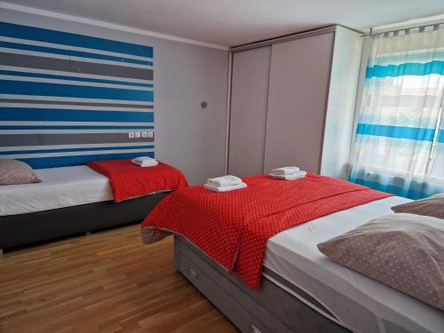 Patricia House في ليوبليانا: غرفة نوم بسريرين مع مرياح احمر