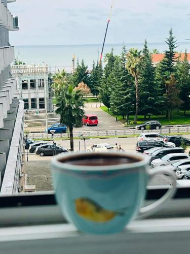 a cup of coffee sitting on a window sill at holiday apartment in Batumi