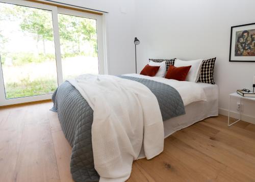 um quarto branco com uma cama grande e uma janela em Halltorp Townhouse em Borgholm