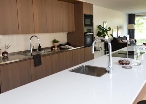 a kitchen with white counter tops and wooden cabinets at Halltorp Townhouse in Borgholm
