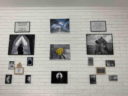 a white brick wall with pictures on it at Супер-квартира в самой эко-зеленой части Алматы in Almaty