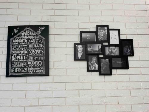 a group of pictures on a white brick wall at Супер-квартира в самой эко-зеленой части Алматы in Almaty