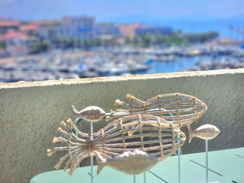 a bird sculpture sitting on top of a ledge at Superbe appartement avec vue mer et terrasse in Sausset-les-Pins