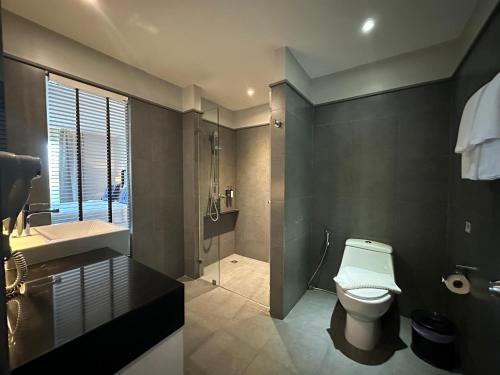 a bathroom with a toilet and a sink and a shower at The Sala Pattaya - SHA Certified in Jomtien Beach