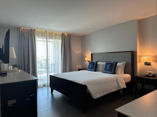 a bedroom with a large bed with blue pillows at The Sala Pattaya - SHA Certified in Jomtien Beach