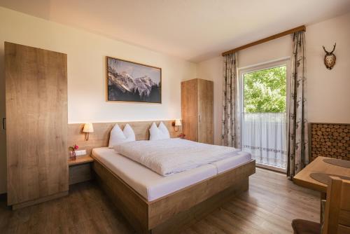Un dormitorio con una cama grande y una ventana en Apartments Morandell en Fulpmes