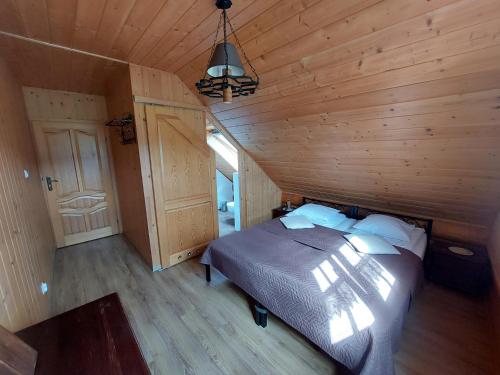 a bedroom with a bed in a wooden cabin at Bieszczadzkie Marzenie in Wetlina