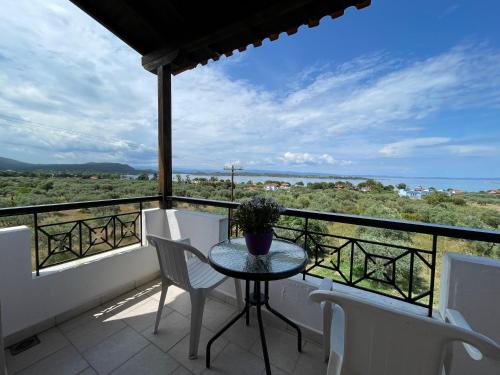 una mesa en un balcón con vistas al océano en BALCONAKI APARTMENTS IN VOURVOUROU, en Vourvourou