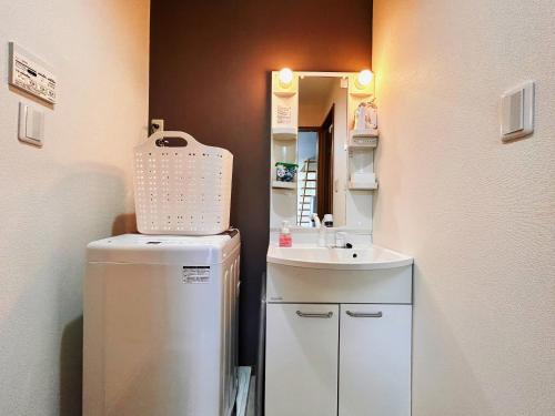 a small bathroom with a sink and a refrigerator at Summit Villa 100sqm Osaka Nakazakicho Station in Osaka