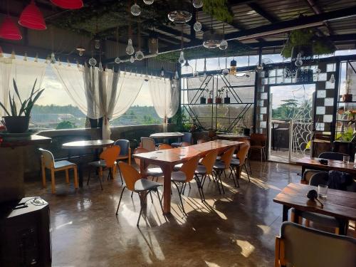 a restaurant with wooden tables and chairs and windows at Balai ni Meno in Butuan