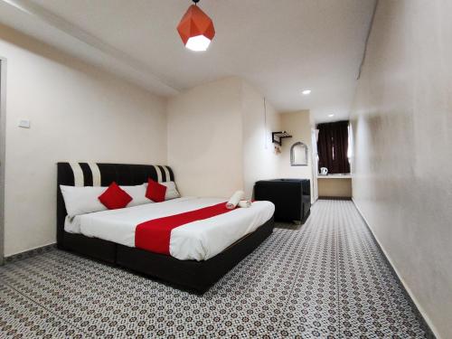 una camera da letto con un grande letto con cuscini rossi di Ar Rayyan Hotel a Tanah Rata
