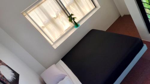a bedroom with a black bed and a window at Balai ni Meno in Butuan