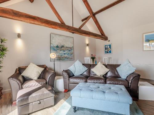 a living room with a couch and a table at Wheelhouse Cottage in Ullingswick