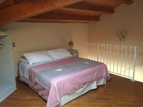 Emily house في بوزالو: غرفة نوم بسرير وبطانية وردية