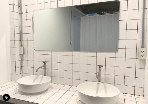 a bathroom with two sinks and a mirror at BAAN650 Hostel in Ban Kohong