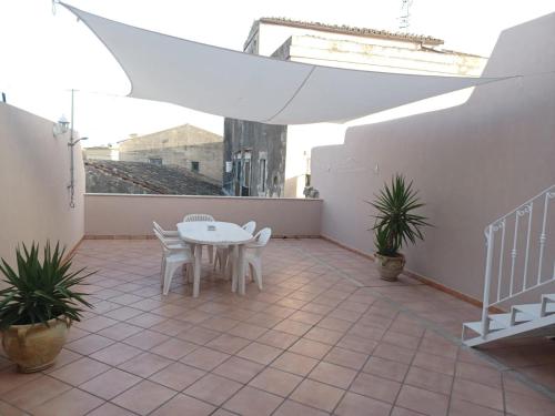 a patio with a white table and chairs on it at Emily house in Pozzallo