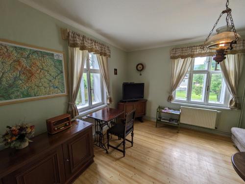a living room with a desk and a table with a tv at Chaloupka na konci světa in Ves Raškov