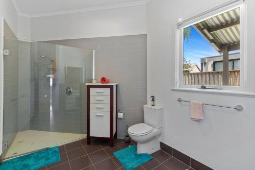 a bathroom with a shower and a toilet and a window at Mid Century 1930 Beautifully renovated Californian Bunglow in Newtown and Chilwell