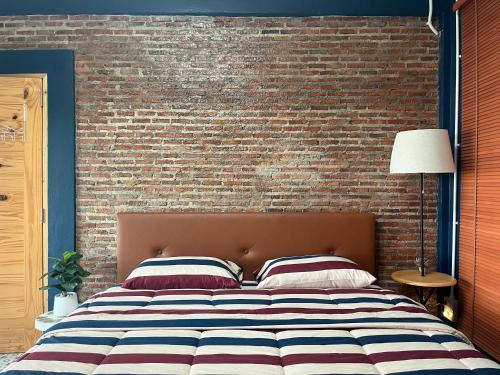 a bed in front of a brick wall at Blessing Moon Pool Villa Khaoyai in Ban Tha Wua Tai