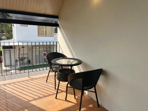 a balcony with three chairs and a table and a window at Blessing Moon Pool Villa Khaoyai in Ban Tha Wua Tai