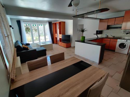 een keuken en een woonkamer met een tafel en een bank bij Bas de villa indépendant. 10min de la mer in Biot