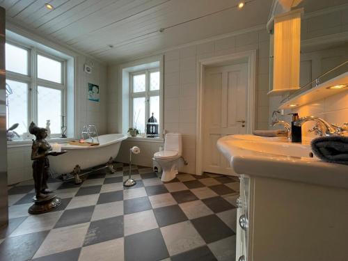 y baño con bañera, lavabo y aseo. en Monshaugen Home, en Sykkylven