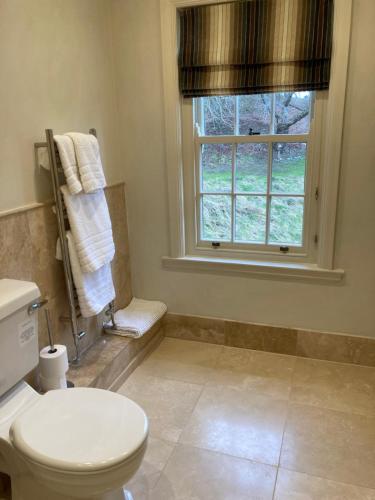 a bathroom with a toilet and a window with towels at Gallows Hill in Scarborough