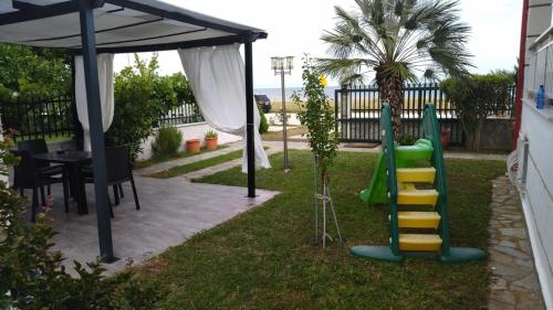 a backyard with a playground with a table and a play structure at Seaview Apartment & semi basement seaview Apartment in Nea Vrasna
