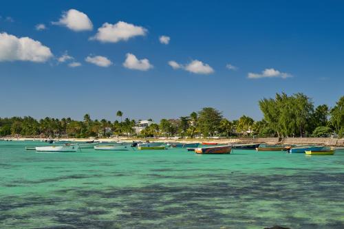 a group of boats in the water on a beach at Les Estivales Beachfront Suites & Penthouses with LOV in Trou aux Biches