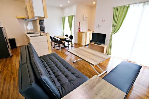 a living room with a couch and a table at JOUJI HOUSE in Kishaba