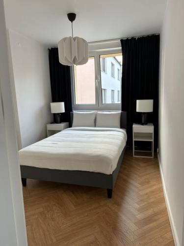 1 dormitorio con cama y ventana en Mały Kwadrat Katowice, en Katowice