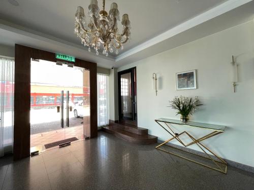 a lobby with a glass table and a chandelier at Hotel Bundusan in Kota Kinabalu
