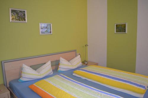 a bedroom with a bed with yellow and blue at Ferienwohnungen Holder in Anhausen