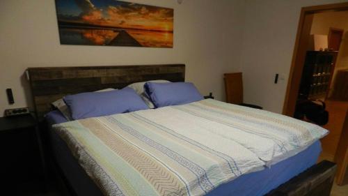 ein Bett mit einer blauen und weißen Bettdecke in einem Schlafzimmer in der Unterkunft Ferienwohnung Jung in Hohenburg