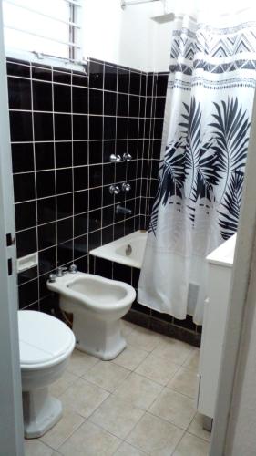 a bathroom with a toilet and a shower curtain at Thot Aparts in Rosario