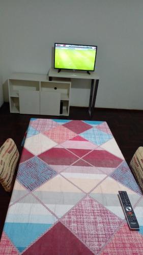 sala de estar con TV y alfombra colorida en Thot Aparts en Rosario