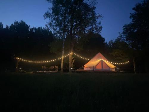 Tienda iluminada por la noche con luces en A Romantic & Luxurious stay in the nature of Karula National Park. en Ähijärve